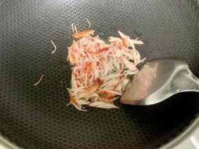 锅里下适量食用油烧热，下蟹柳丝炒香。