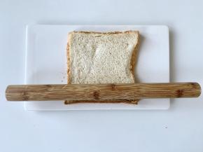 把吐司片用擀面杖擀平。