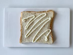 在吐司片上挤上沙拉酱。