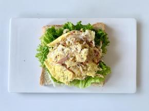 在生菜叶上放上蟹柳滑蛋，磨上黑胡椒碎。