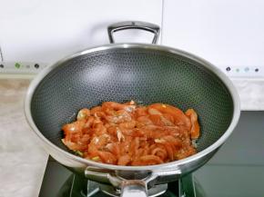 起油锅倒入腌制好的鸡肉条翻炒。