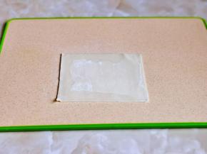 取一张馄饨皮，三边抹水。