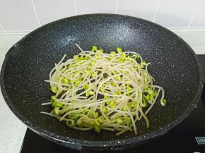 利用锅里的底油把豆芽煸炒微软。