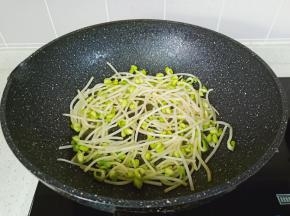 利用锅里的底油把豆芽煸炒微软。