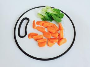 胡萝卜削皮切成滚刀块，青菜一片一片摘洗干净。