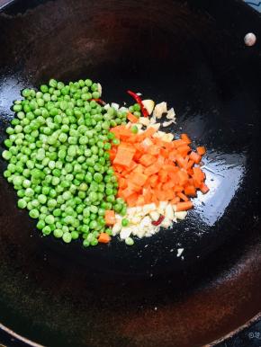 放入青豆，胡萝卜丁翻炒片刻！