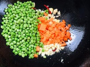 放入青豆，胡萝卜丁翻炒片刻！