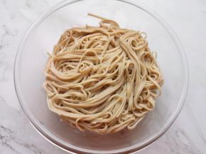 将煮熟的面条捞出，放在大一点的盆里。