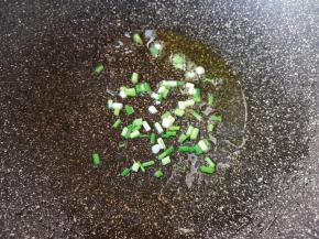 锅里继续倒油烧热，下入小葱葱白炒香。