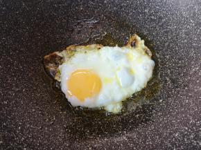 不粘锅里倒入食用油烧热，打入一个鸡蛋。