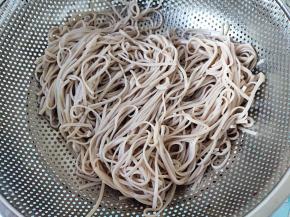 将煮好的面条捞起，过凉水冲洗降温。