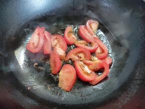 锅烧热，倒入少量油，比平常炒菜要少。倒入番茄煸炒出红色。