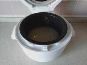 大米清洗好后，加入清水按煮饭键开始煮饭。