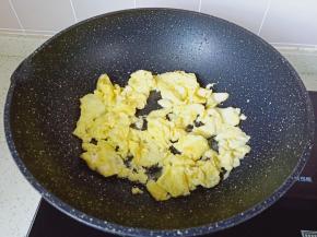 等鸡蛋液凝固，用筷子快速把鸡蛋搅散。