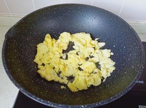 等鸡蛋液凝固，用筷子快速把鸡蛋搅散。