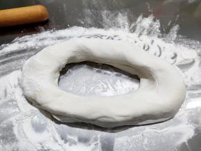 案板上撒一层面粉防粘，将面团从盆中取出，不用揉，从中间抠一个洞，然后慢慢搓成条。
