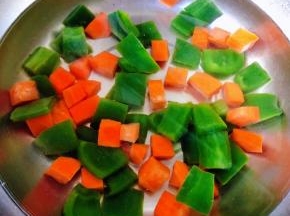 青椒和胡萝卜切成小块放入开水中焯水断生后立即放入冷水中过凉沥干水份