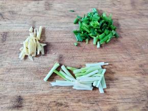 姜切丝，小葱的葱白和葱叶分开，葱白切寸段，葱叶切碎。