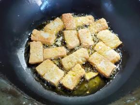 豆腐底下煎得有点焦黄了，就小心一一翻过来。如果有粘锅的，用锅铲兜底铲几下，不要乱铲，会铲碎的。豆腐各个面都要煎到金黄色，煎的过程中，可以端着锅转动几下位置，让豆腐煎得更均匀一些。