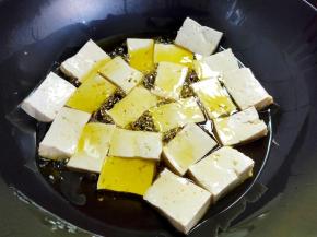锅里倒入比较多的菜籽油，烧到有点烫了（手放到油上方十几厘米处感觉热的），下豆腐块中小火慢煎。不要随便乱翻动，容易把豆腐翻碎。如果豆腐比较多，可以分两次煎。