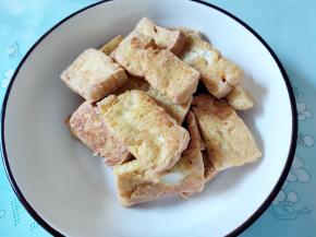 将煎好的豆腐捞起。