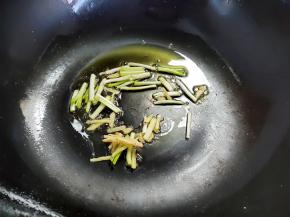 多余的油倒出，留少许底油，下姜丝和葱白煸香。多出的油可以留着炒其它菜，不要浪费，炸一两次的油没有关系，可以继续烧菜吃。