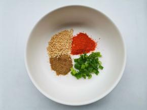 碗中放1勺葱花，辣椒粉，白芝麻，五香粉。