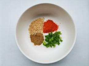 碗中放1勺葱花，辣椒粉，白芝麻，五香粉。
