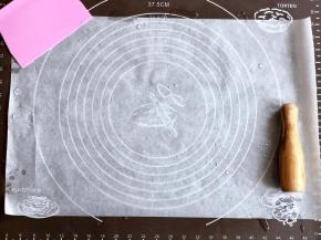 准备一张油纸，面上撒上一些纯净水或熟油防粘。