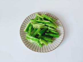 青椒去籽对半切开，然后切成条形状。