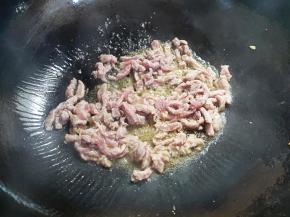 再倒适量油，下牛肉丝，迅速扒开，炒至牛肉变色。