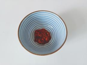 碗里放入两勺辣椒酱。