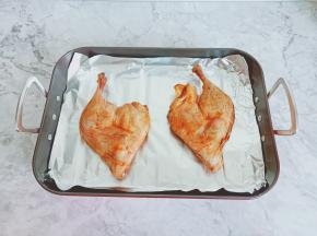 烤盘铺上一张锡纸，把腌制好的鸭边腿放在上面。