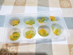 将水果粒分装至果冻盒中。