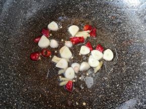 炒锅内继续倒油烧热，下入蒜片、姜丝和干红辣椒炒香。