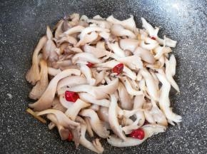 下入蘑菇翻炒至变软。