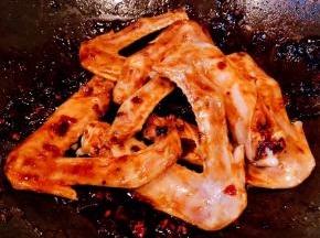 放入鸭翅大火快速翻炒入味使鸭翅均匀的裹上酱料