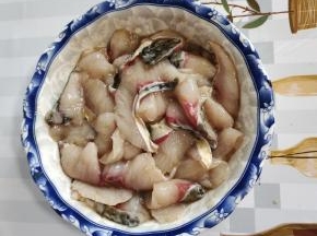 用手把鱼片挤干水分，加入盐料酒，鸡精胡椒粉，再打入一个蛋清抓拌均匀，搅打上劲，再加入一勺干淀粉继续抓拌均匀！最后加入一汤匙食用油再次抓拌均匀备用！