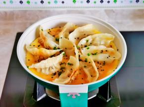 小火煎至蛋液凝固，撒上熟黑芝麻与葱花。