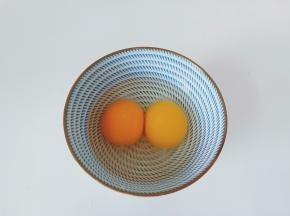 把两个新鲜的鸡蛋嗑入碗里。