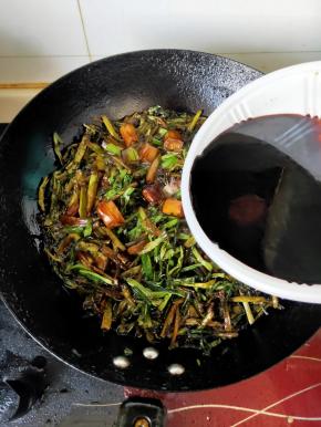 在倒入葱叶继续来回翻炸，葱叶刚变色就加入调好的酱汁