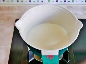 牛奶倒入奶锅中加热，倒入杯中。