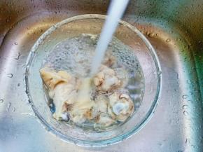 焯水过后的鸡腿用清水把表面浮沫清洗干净，并且把鸡腿控干水分或者用厨房纸巾擦干。