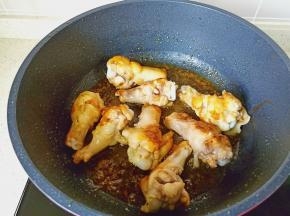 中小火慢慢熬至冰糖融化，加入鸡腿快速翻炒上色。