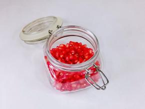 首先放入三分之一的石榴果肉在密封罐里。