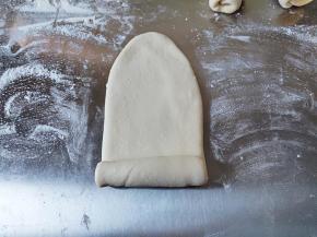 取一个面团，用擀面杖擀成牛舌状，然后从细的那头卷起。可以在案板上撒一层薄薄的干粉防粘，不能撒多了，做吐司可不需要像做馒头那样撒干粉呛面哈。