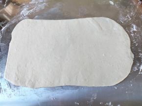 将前面揉好的面团分成2份，取1份擀成长方形或圆形，刷一层薄油。