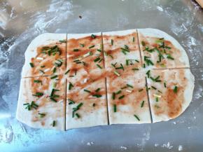 接着刷上前面拌好的酱，酱不能抹太多，撒上一点葱花，用菜刀或刮板分割成若干份，中间留至少一厘米的空档不切。