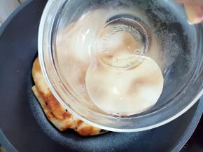 两面都煎的微焦后，沿着锅边倒入小半碗热水，盖上锅盖，转小火焖到水干。如果怕中间太厚不够熟，可以将饼翻一个面，再加一次水焖到水干。