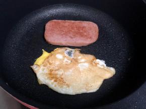 平底锅热油，下鸡蛋煎熟，切一片午餐肉两面煎好。